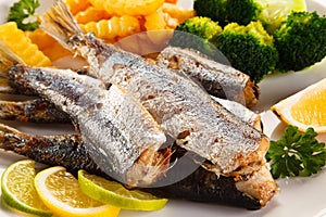 Fried herrings, chips and vegetables
