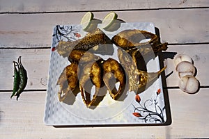 Fried hilsa fish, chili, onion close up shoot.