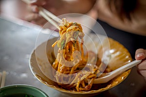 Fried Hokkien Noodles tong by chopsticks ready to eat in the southern of Thailand