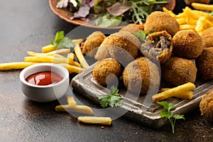 Fried Homemade beef Bitterballen with dijon mustard, ketchup and french fries