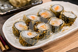 Fried hossomaki sushi rolls with fresh raw salmon and white rice photo