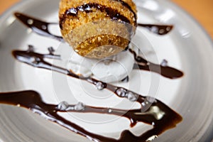 Fried ice cream with chocolate syrup and cream on plate