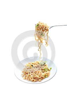 Fried instant noodles with cabbage and egg stabbing in silver fork on plate