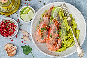 Fried king prawns with garlic, pepper, lime and parsley cilantro. Large shrimp. Langoustine. Delicious dinner with pasta tagliat