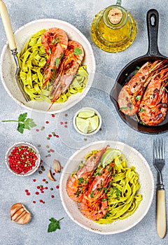 Fried king prawns with garlic, pepper, lime and parsley cilantro. Large shrimp. Langoustine. Delicious dinner with pasta tagliat