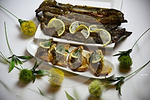 Fried lampreys on a sandwich on a white plate