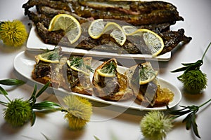 Fried lampreys on a sandwich on a white plate