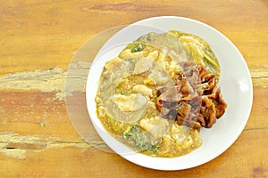 Fried large rice noodles dressing with chicken and vegetable in gravy sauce on plate