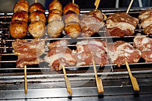 Fried meat balls a grill on a stick in sauce