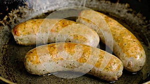 fried meat sausages with a crust in a pan