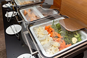 Fried meat on skewers and other appetizers in a food warmer on a buffet table in a hotel restaurant