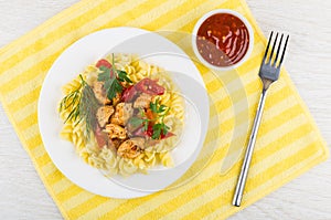 Fried meat, sweet pepper, fusilli, ketchup on napkin, fork