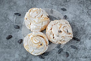 Fried meringue cookie with black raisines on the grey marble background