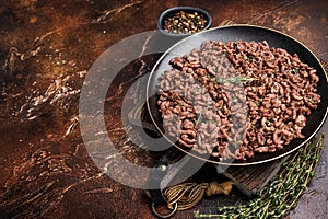 Fried mincemeat, cooked forcemeat in a plate. brown background. top view
