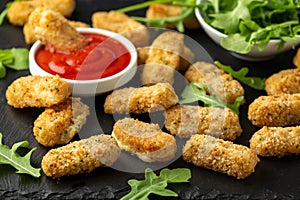 Fried mozzarella cheese sticks in breadcrumbs with ketchup sauce and wild rocket leaves