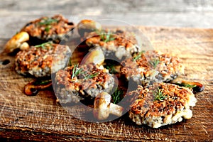 Fried mushroom cutlets decorated with dill on a wooden background