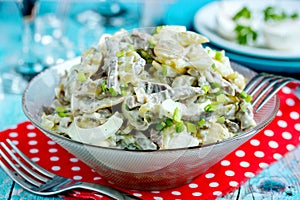 Fried mushroom, meat, onion and egg salad in a glass bowl