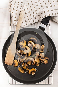 Fried mushroom with thyme and peppercorn on a pan