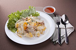 Fried noodle with chicken with sauce, spoon and fork for lunch