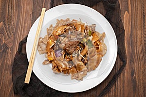 Fried noodles with vegetables and beef in white dish