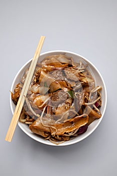 Fried noodles with vegetables and beef in white dish