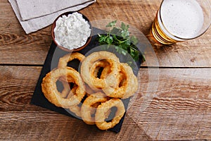 Fried onion rings in batter with sauce