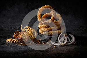 Fried onion rings on a black background.