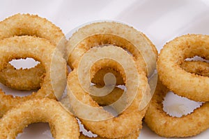 Fried onion rings in white plate on white background