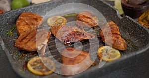 Fried pieces of Organic Tuna Steak on a hot grill frying pan