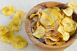 Fried plantain chips in a wooden bowl. photo