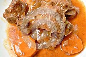 Fried pork bone with slice carrot and onion with swet and sour sauce on plate photo