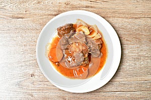 Fried pork bone with slice carrot and onion with swet and sour sauce on plate photo