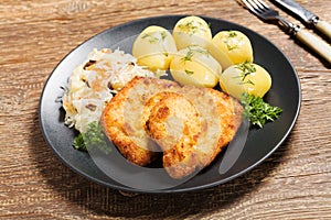 Fried pork chop in breadcrumbs, served with boiled potatoes and cabbage. Polish dish