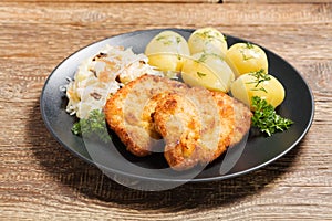 Fried pork chop in breadcrumbs, served with boiled potatoes and cabbage. Polish dish