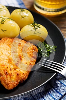 Fried pork chop in breadcrumbs, served with boiled potatoes and cabbage. Polish dish