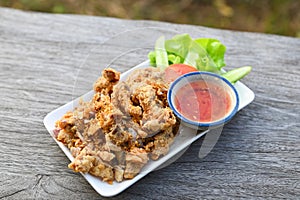 Fried pork intestine with garlic with sauce on plate - pork offal Thai food or snacks