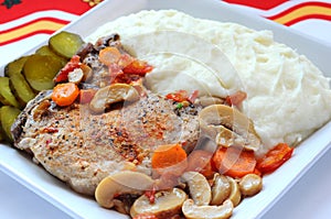 Fried pork meat with mashed potatoes and legumes