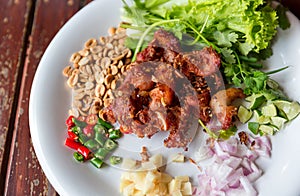 Fried pork rib served with side dish of Garlic, Chilli and Nut on plate. Favorite preservation food. Fried sour pork. Fried fermen photo