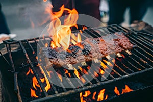 Fried pork ribs grilling on open flame, flavorful street food photo