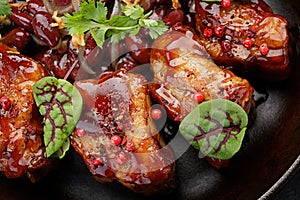 Fried pork ribs with ketchup and herbs. close-up