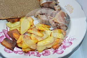 Fried potato dish with cold smoked fish and bread