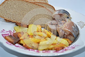 Fried potato dish with cold smoked fish and bread