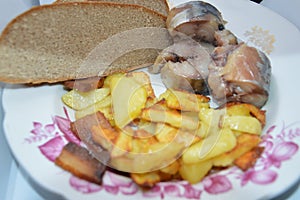 Fried potato dish with cold smoked fish and bread