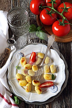 Fried potato gnocchi with cheese and tomatoes