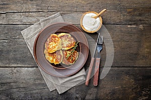 Fried potato pancakes - draniki or deruny on a wooden table. Rustic style.