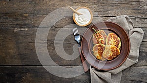 Fried potato pancakes - draniki or deruny on a wooden table. Rustic style.