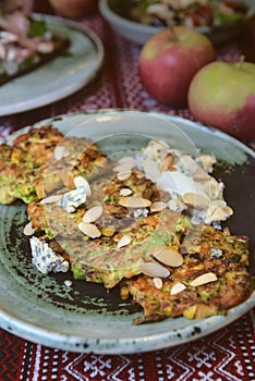 Fried potato pancakes on the old ceramic plate on a rustic wooden table with traditional tablecloth.