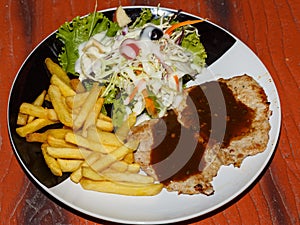 Fried potato, pork, salad on plate