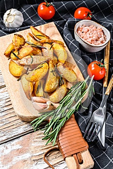 Fried potato wedges, French fries on a wooden cutting board. White background. Top view