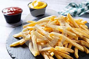 Fried potatoes, french fries on wooden table photo